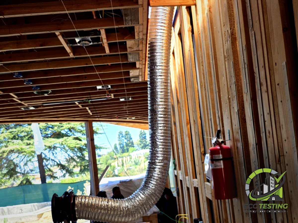 Flexible test duct running through open framing on a new construction site