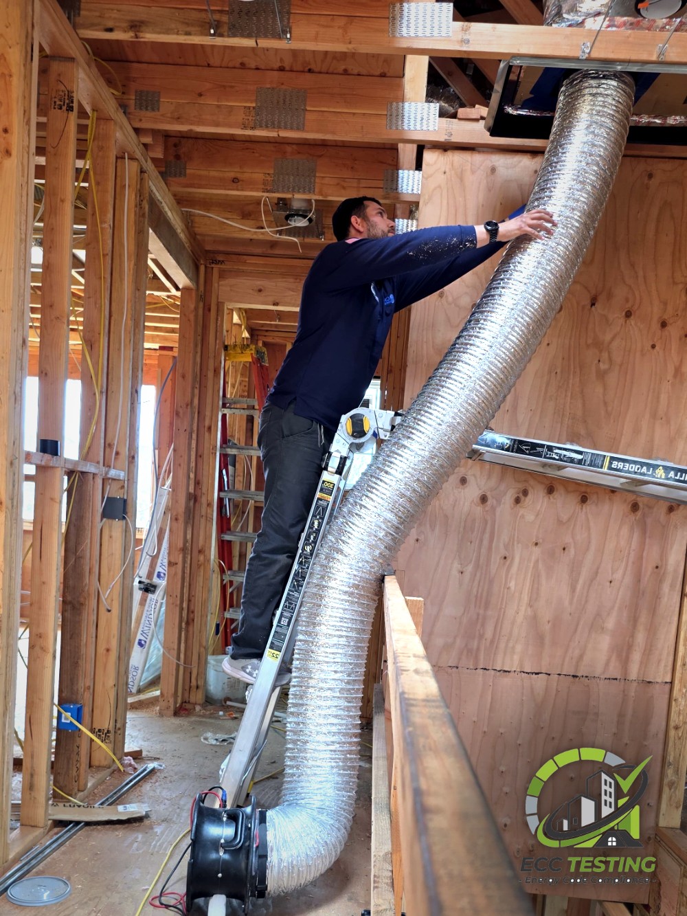 HERS rater connecting a duct blaster to the supply plenum during rough-in testing